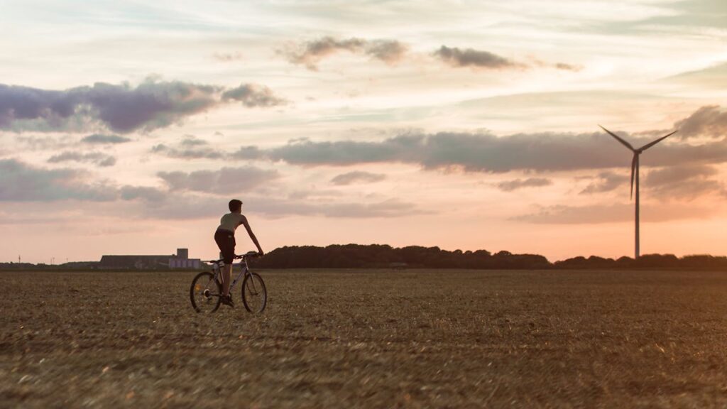 Man Cycling Near Wind Mill